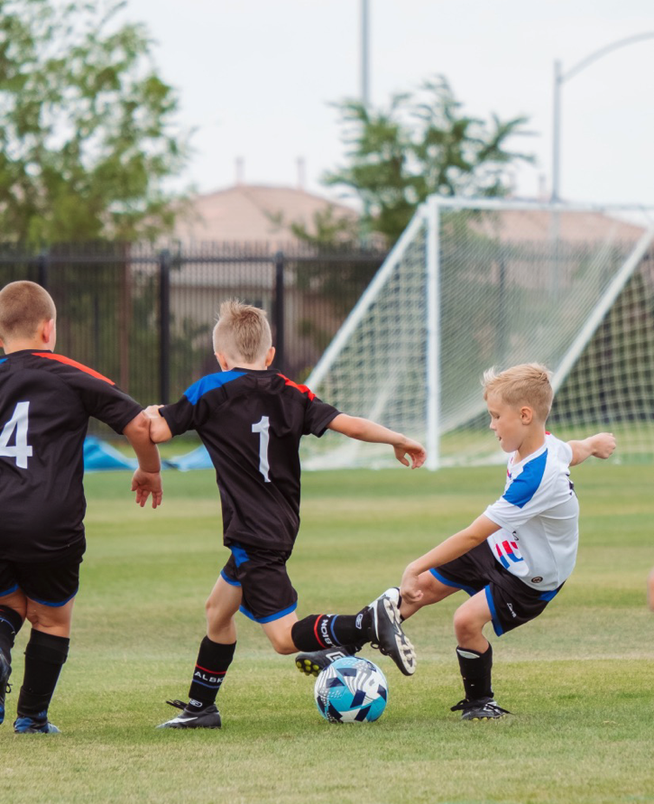 Children playing football on a soccer field.